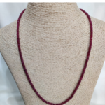 : Elegant ruby stone necklace showcasing faceted beads in deep crimson hues, strung in a continuous loop—an exquisite example of gemstone therapy through Afghan craftsmanship and emotional
